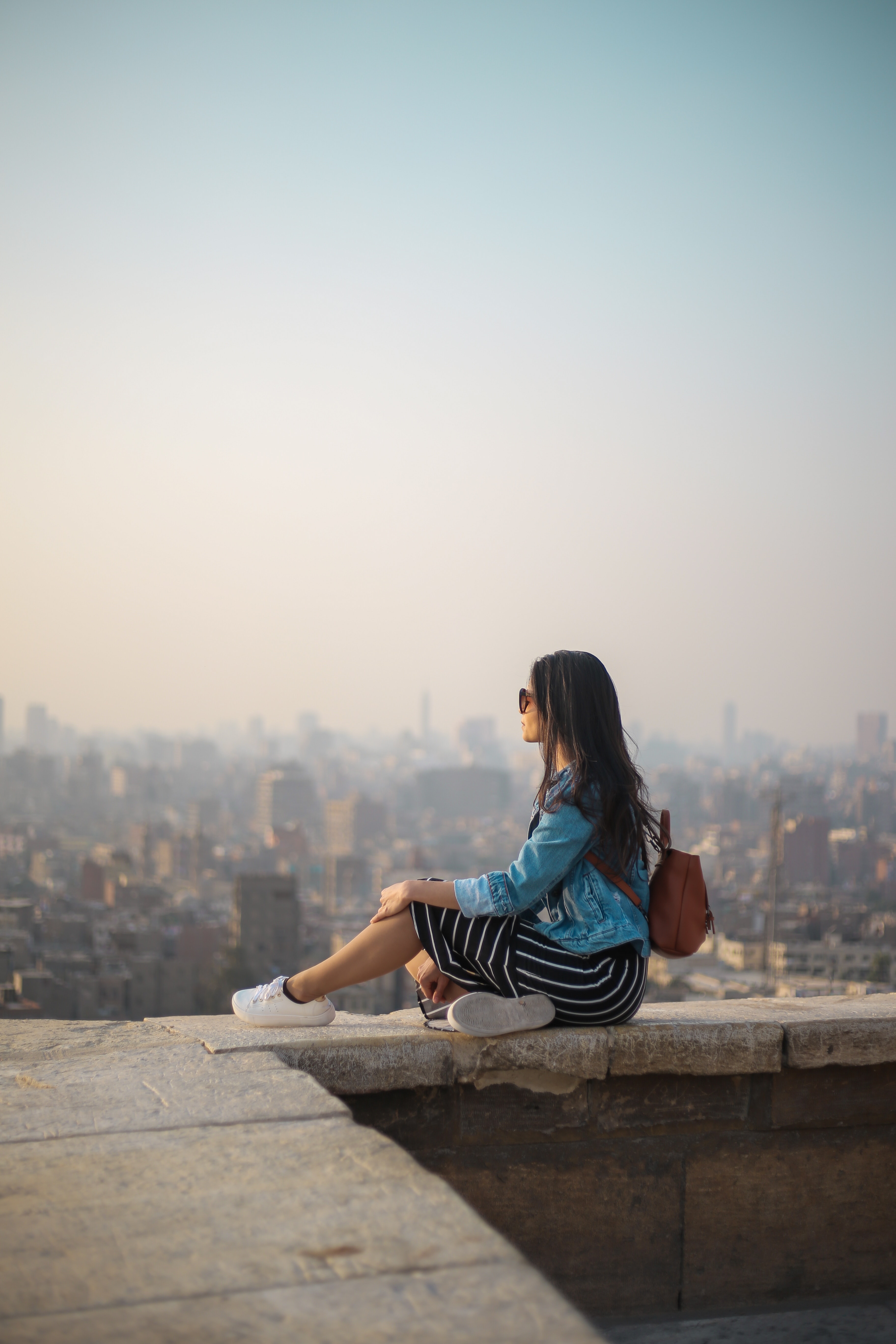 girl sitting on the side of a building