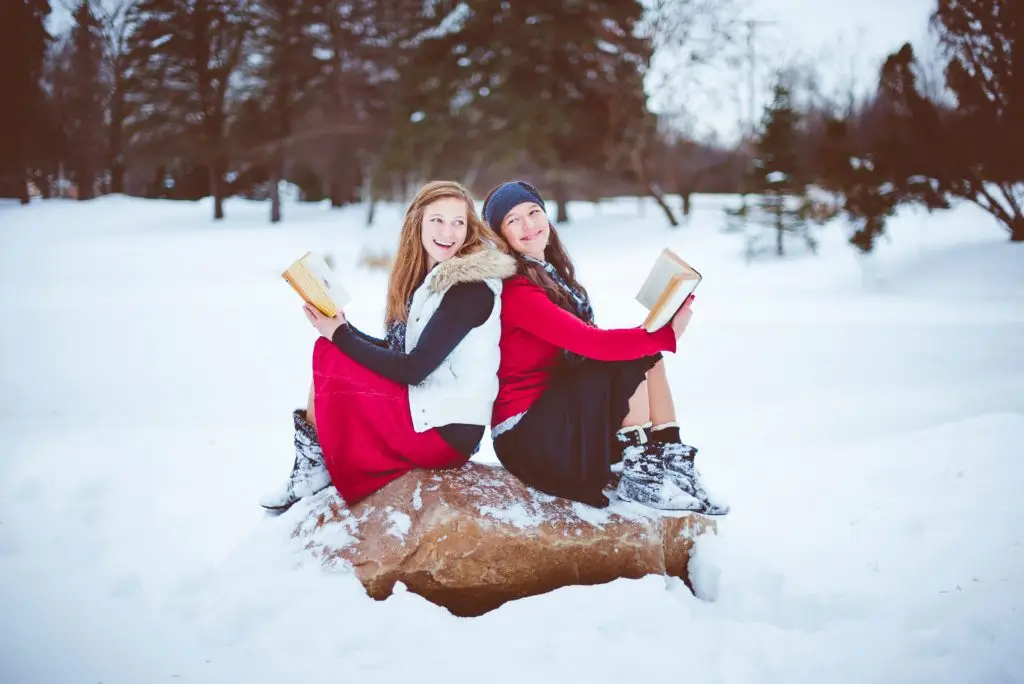 2 girls in the snow with books