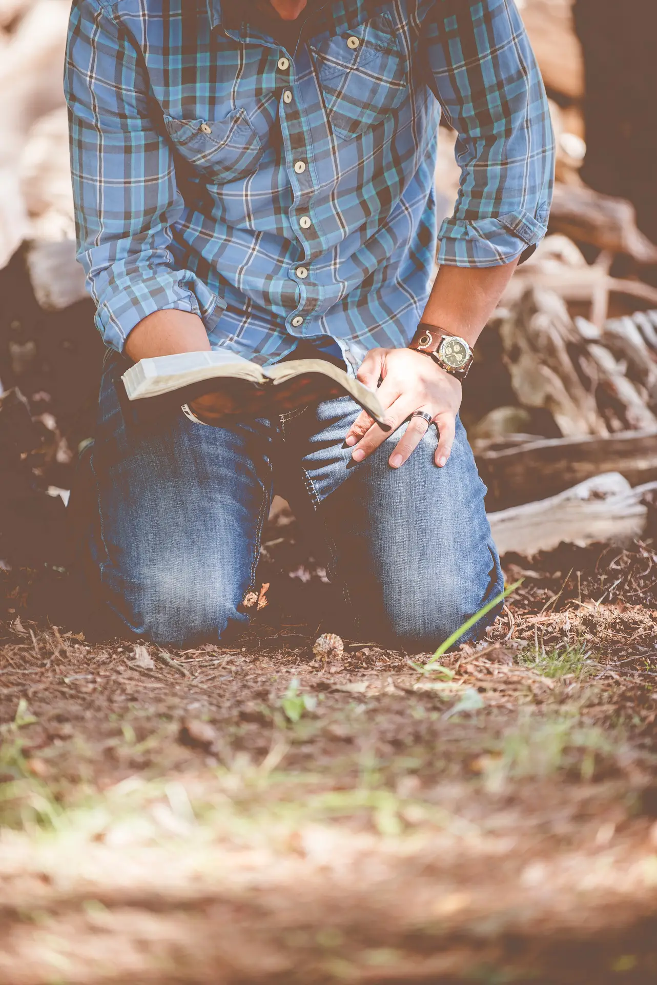 Man on his knees reading Bible