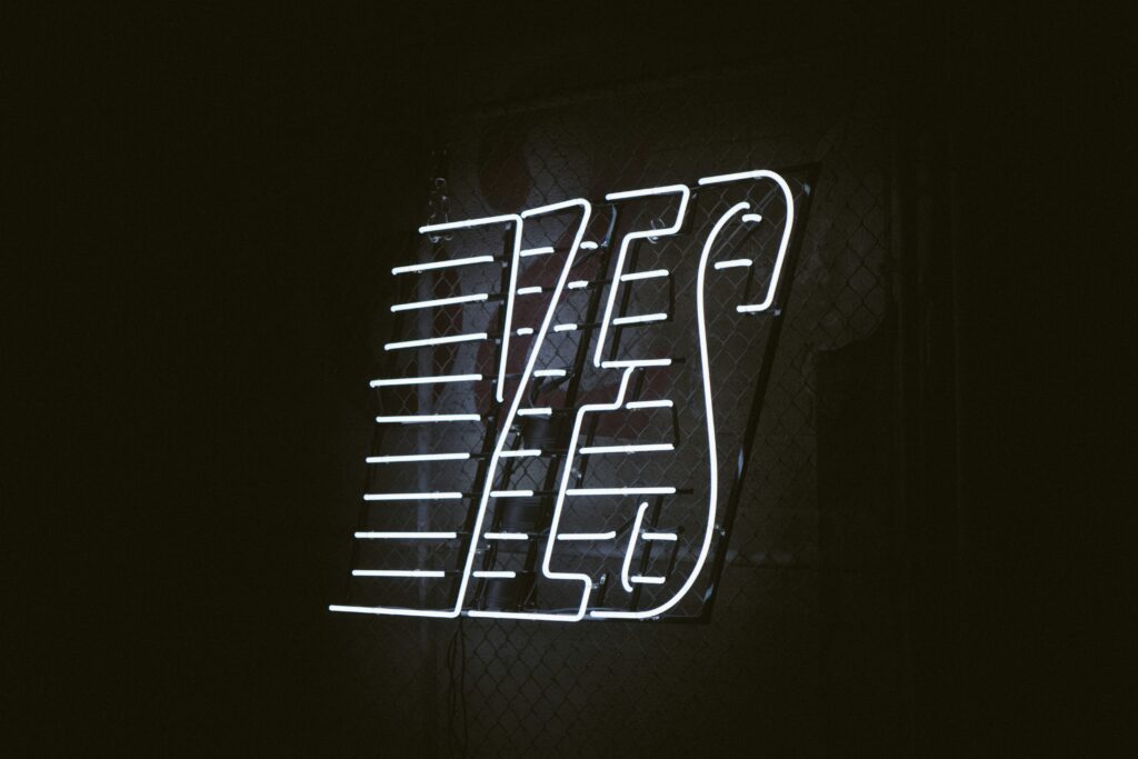 YES in white neon lettering on black background