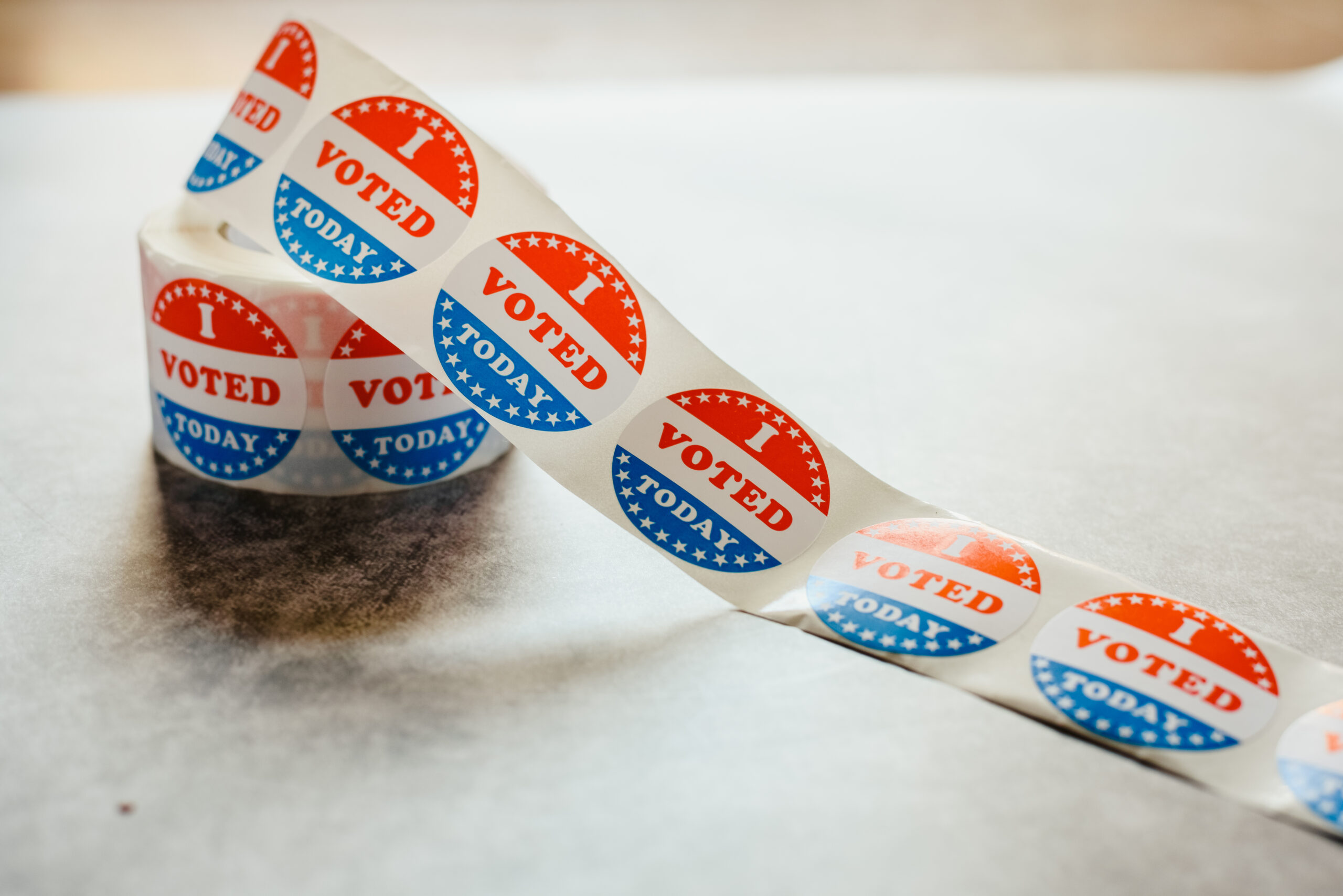 "I voted" circular stickers on a gray background