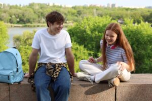 Teenage girl and boy spending time together outdoors